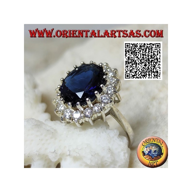 Anello in argento con zaffiro sintetico ovale sfaccettato incastonato contornato da zirconi bianchi