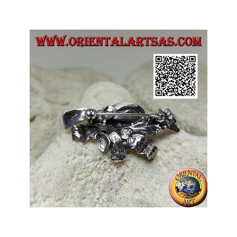 Broche en argent du chasseur avec chapeau et fusil de chasse sur un tapis de lierre