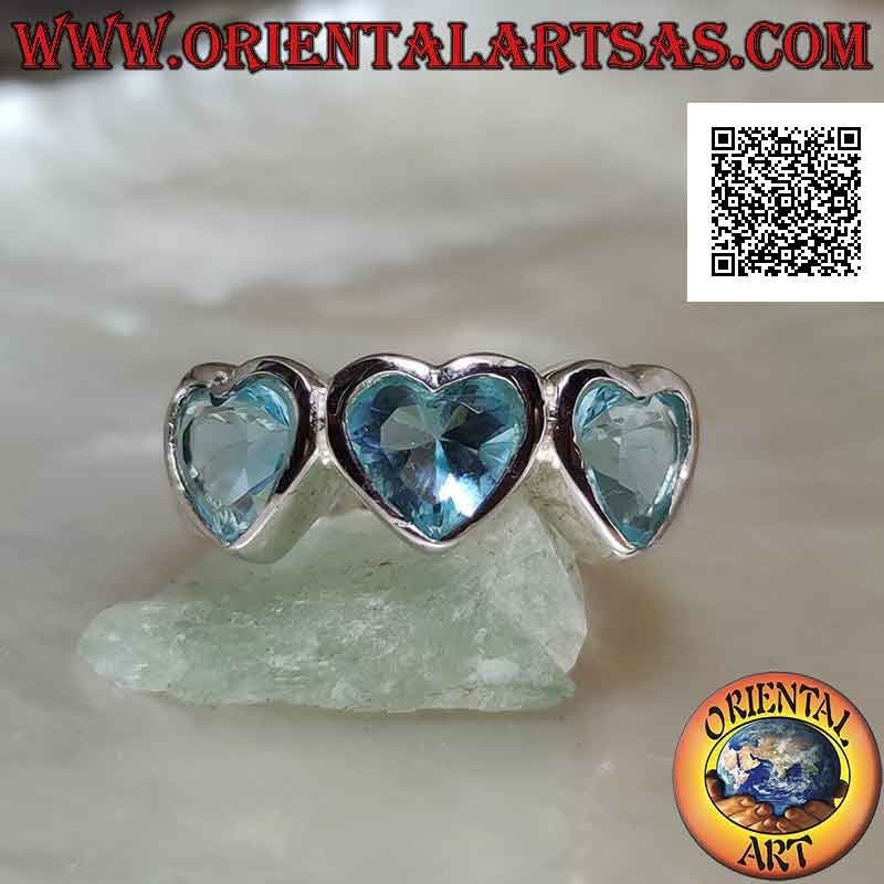 Anillo de plata rodiada lisa con tres corazones de topacio azul sintético