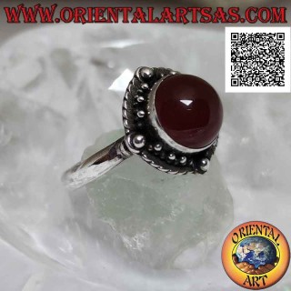 Anello in argento con corniola tonda cabochon contornata da intreccio e pallina sui quattro punti cardinali