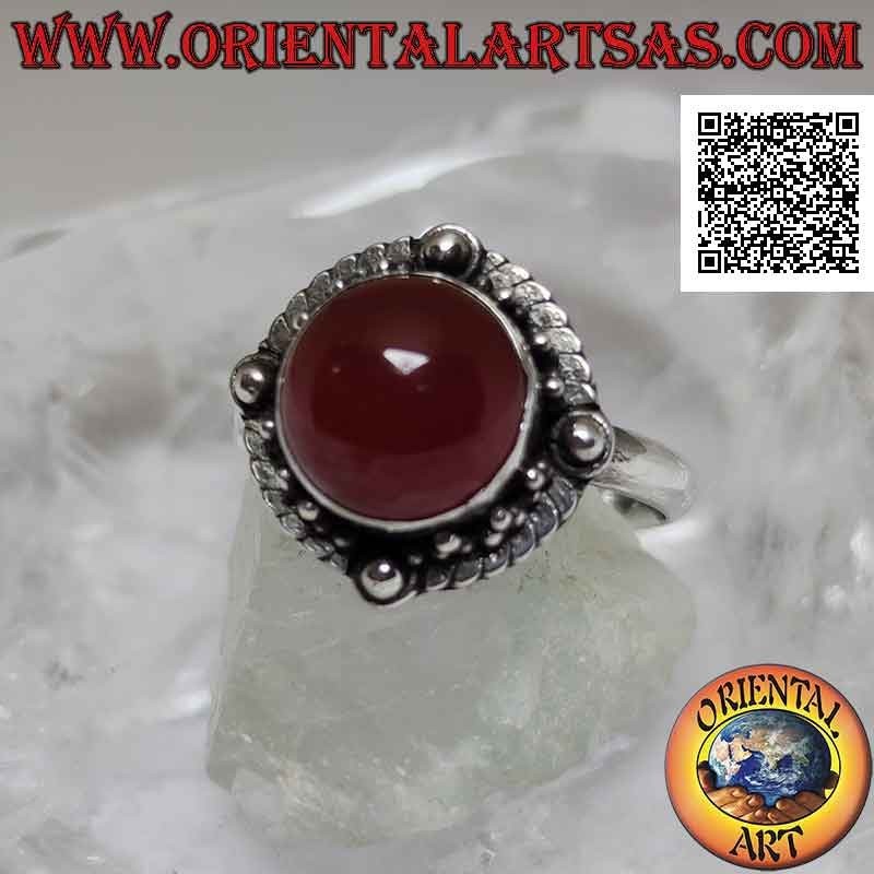 Anello in argento con corniola tonda cabochon contornata da intreccio e pallina sui quattro punti cardinali