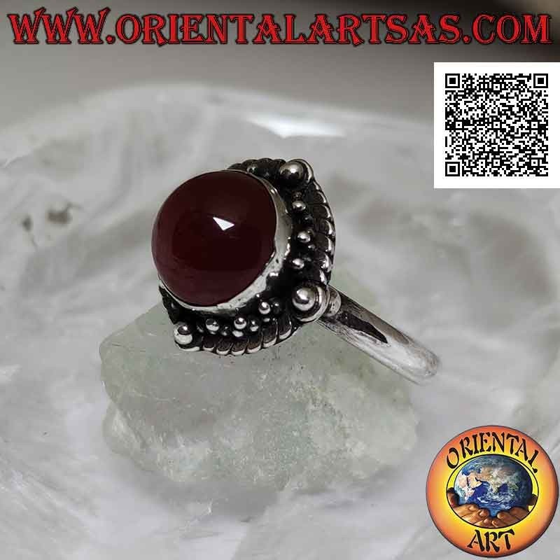 Bague en argent avec cornaline cabochon ronde entourée d'entrelacs et boule sur les quatre points cardinaux