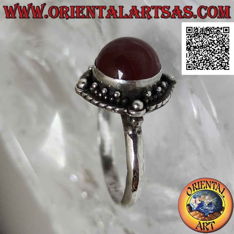 Bague en argent avec cornaline cabochon ronde entourée d'entrelacs et boule sur les quatre points cardinaux