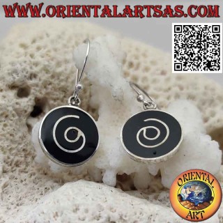 Round silver earrings with spiral on a black resin background