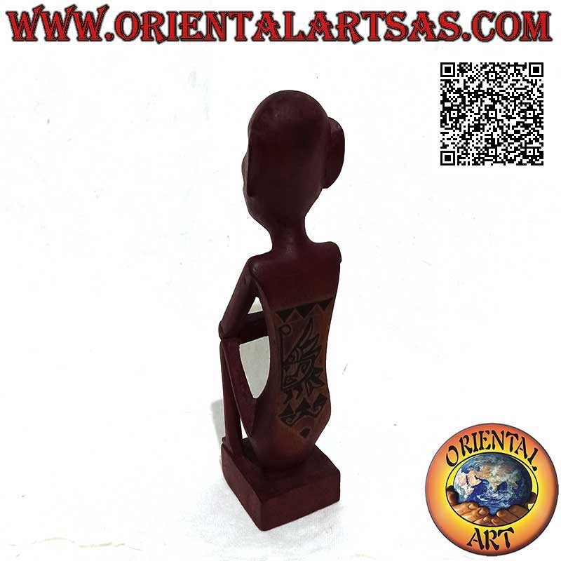 Sculpture of an indigenous thinker with hand painted tribal tattoos in burgundy mahogany wood