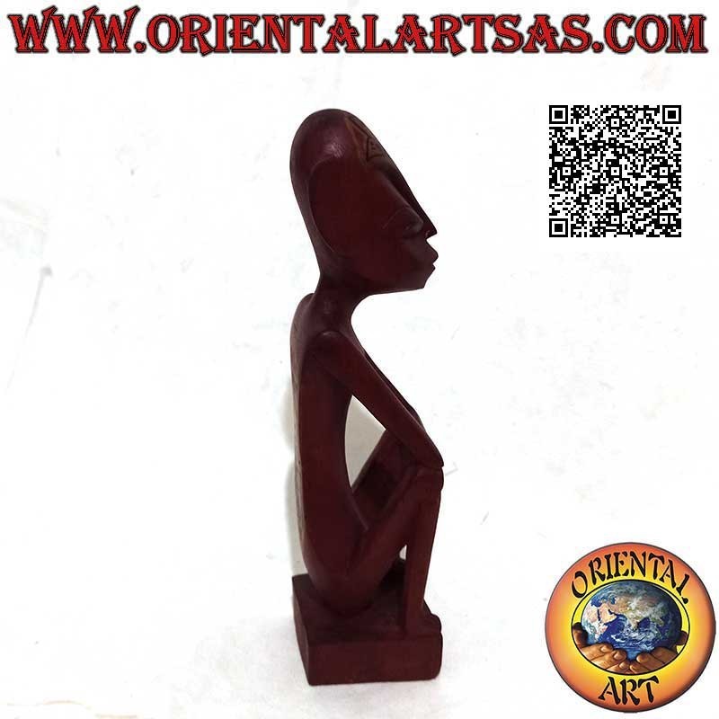 Escultura de un pensador indígena con tatuajes tribales pintados a mano en madera de caoba burdeos