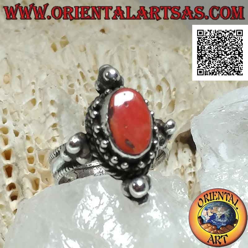 Bague en argent avec corail antique ovale entouré de trio de boules et entrelacs et tris sur les points cardinaux