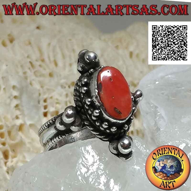 Anillo de plata con coral antiguo ovalado rodeado de trío de bolas y entrelazados y tris en los puntos cardinales