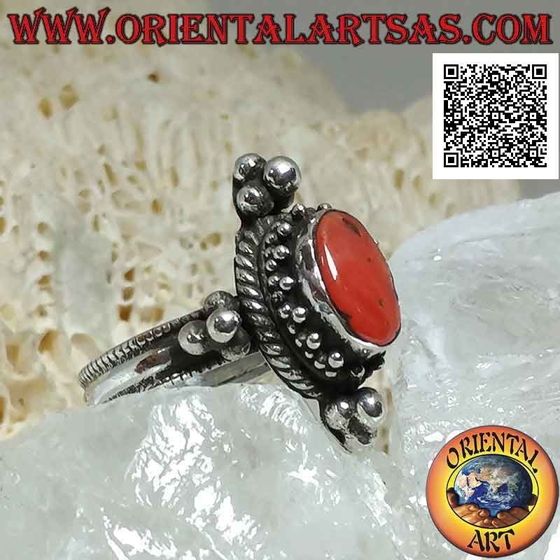 Silver ring with oval antique coral surrounded by trio of balls and intertwining and tris on the cardinal points