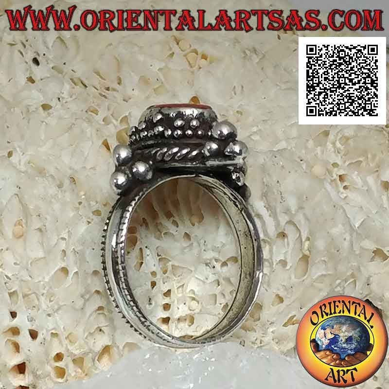 Silver ring with oval antique coral surrounded by trio of balls and intertwining and tris on the cardinal points
