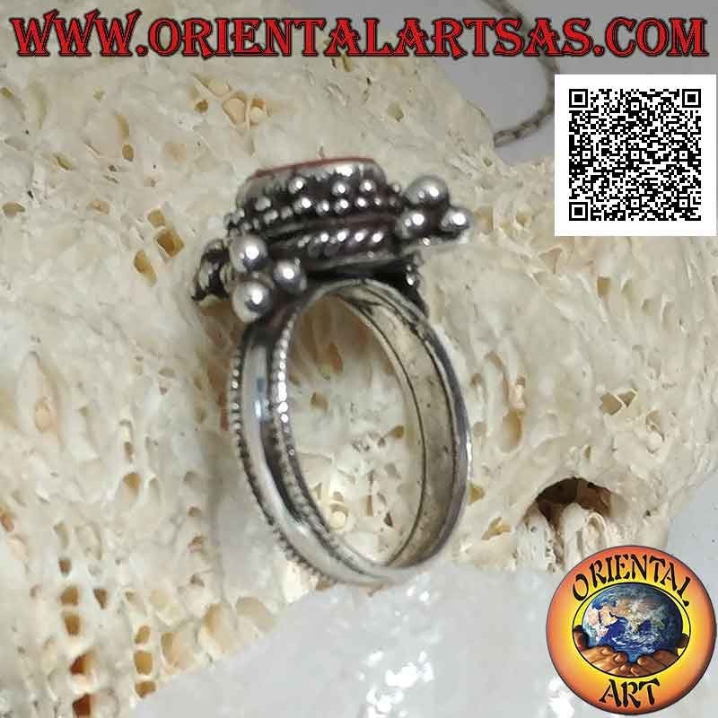 Bague en argent avec corail antique ovale entouré de trio de boules et entrelacs et tris sur les points cardinaux