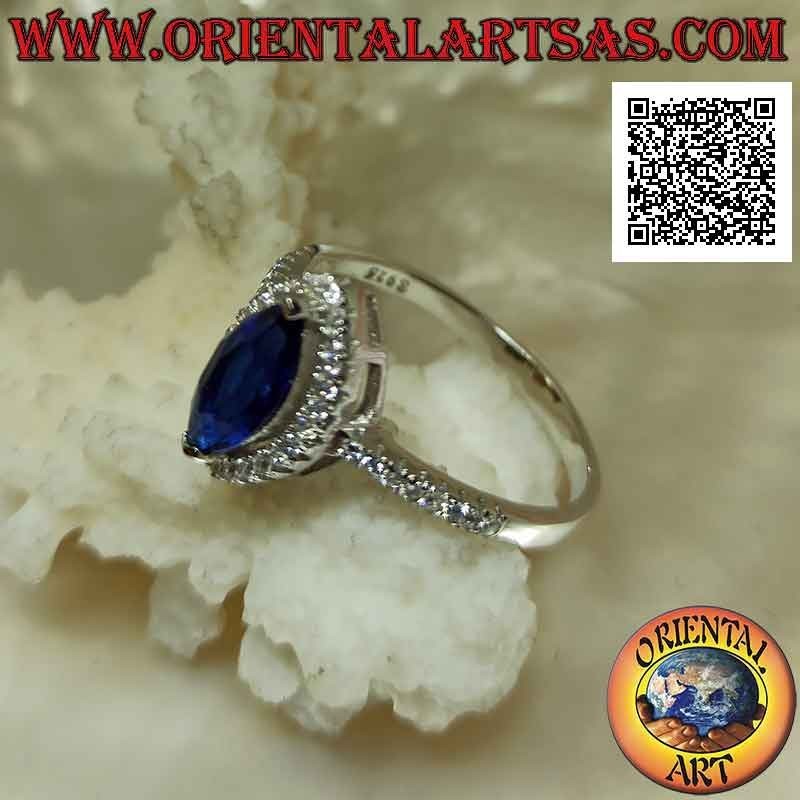 Solitaire style silver ring with synthetic shuttle sapphire surrounded by white zircons