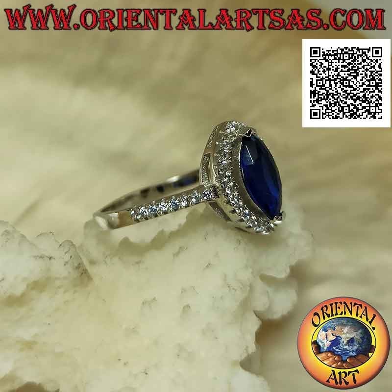 Anillo de plata estilo solitario con zafiro lanzadera sintético rodeado de circonitas blancas