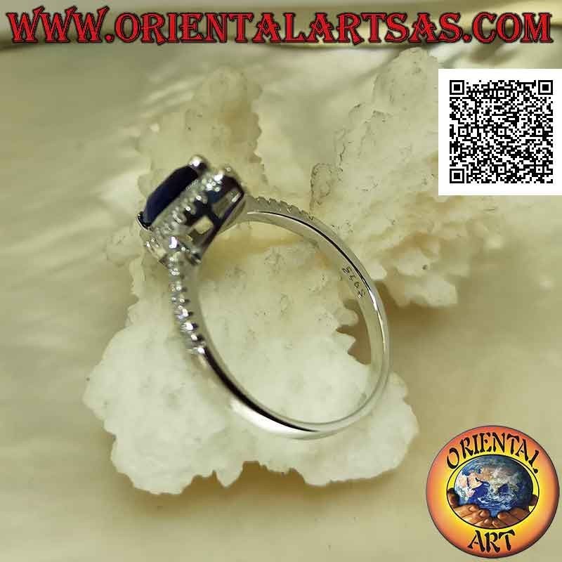 Solitaire style silver ring with synthetic shuttle sapphire surrounded by white zircons