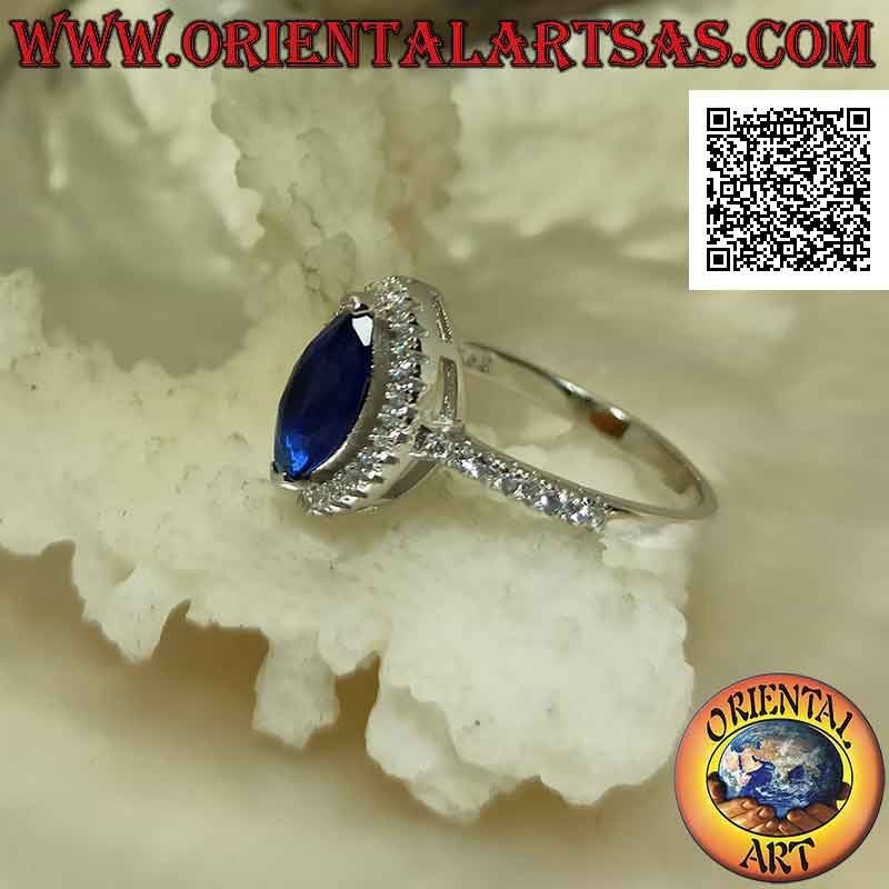 Anello in argento in stile solitario con zaffiro di sintesi a navetta contornato da zirconi bianchi