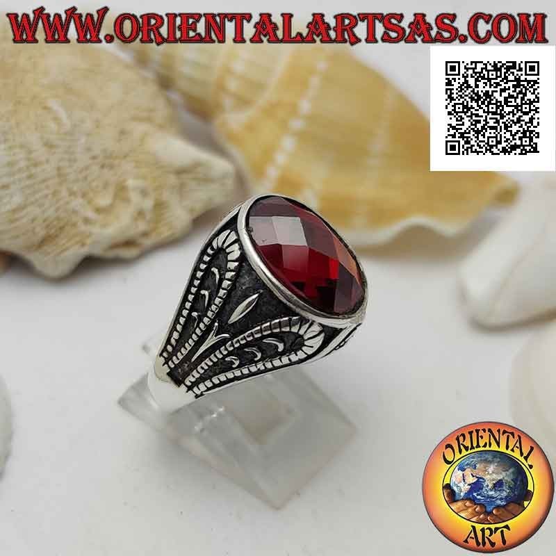 Silver ring with faceted oval garnet and bas-relief oxidized grotesque decoration