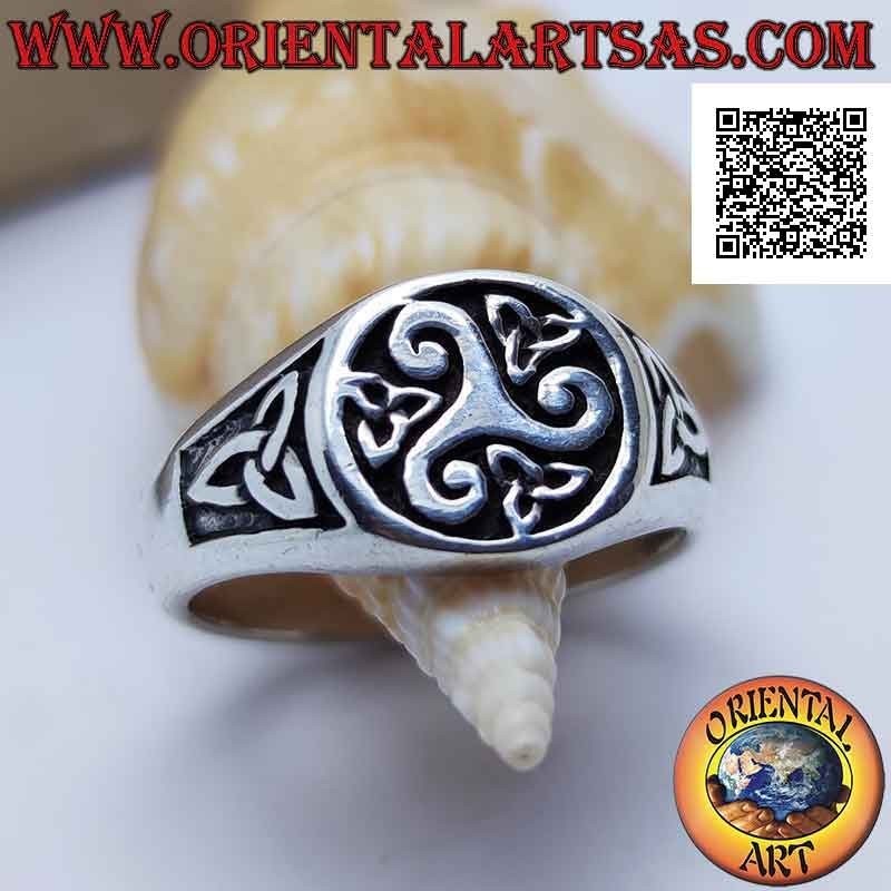 Runder silberner Ring mit zentralem Triskell und Triquetra um und an den Seiten im Basrelief