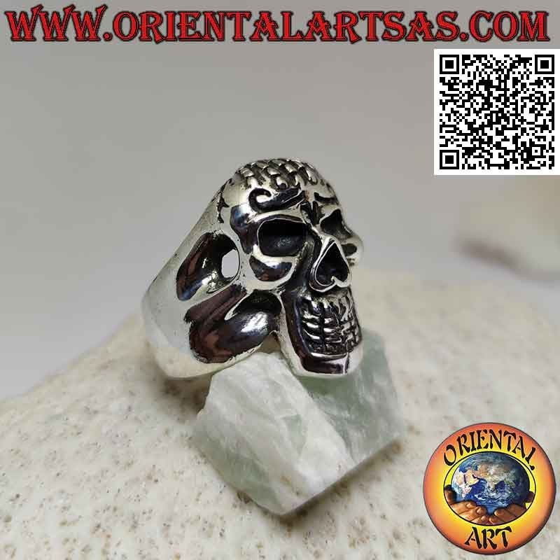 Anello in argento a forma di teschio posseduto con mano sulla fronte