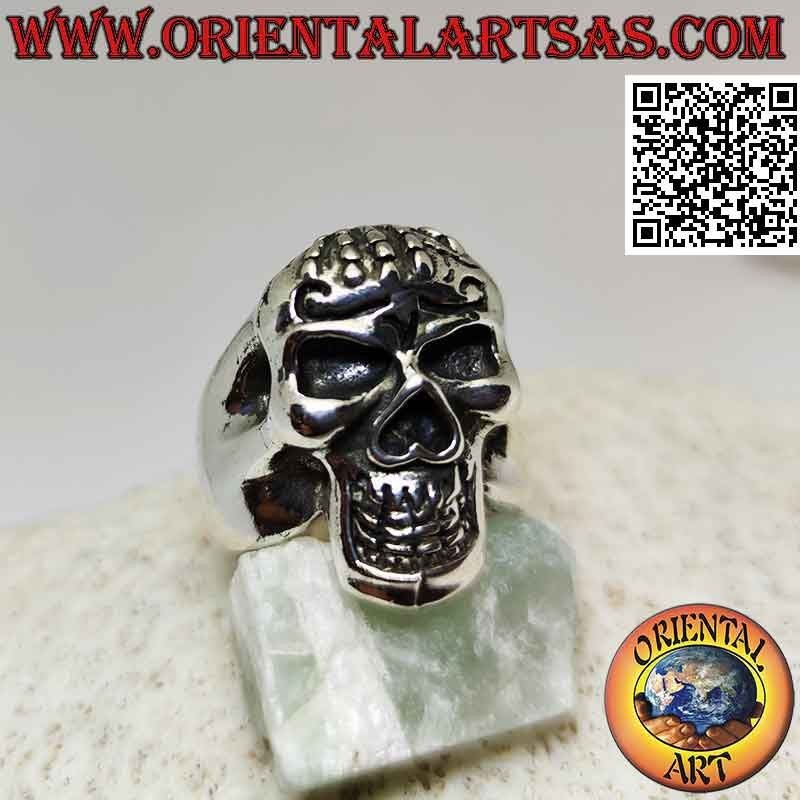 Anello in argento a forma di teschio posseduto con mano sulla fronte
