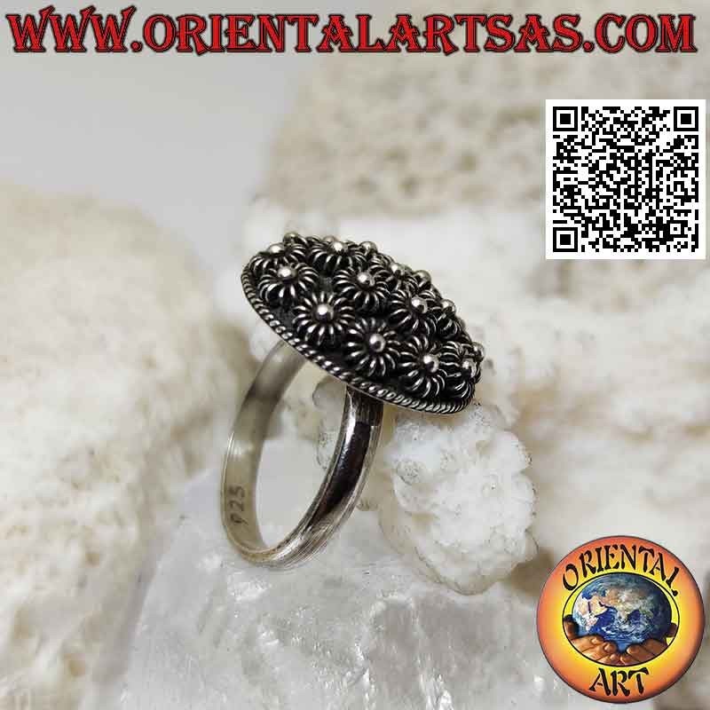 Silver ring with round dome of bas-relief flowers