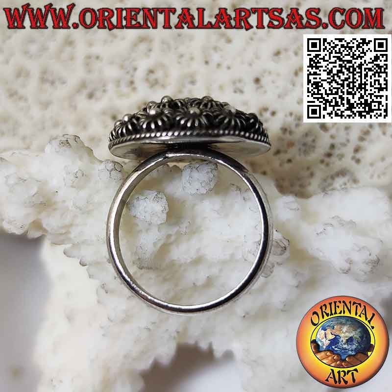 Silver ring with round dome of bas-relief flowers