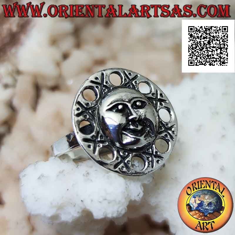 Anillo de plata redondo con una cara en forma de sol y círculos perforados a su alrededor.