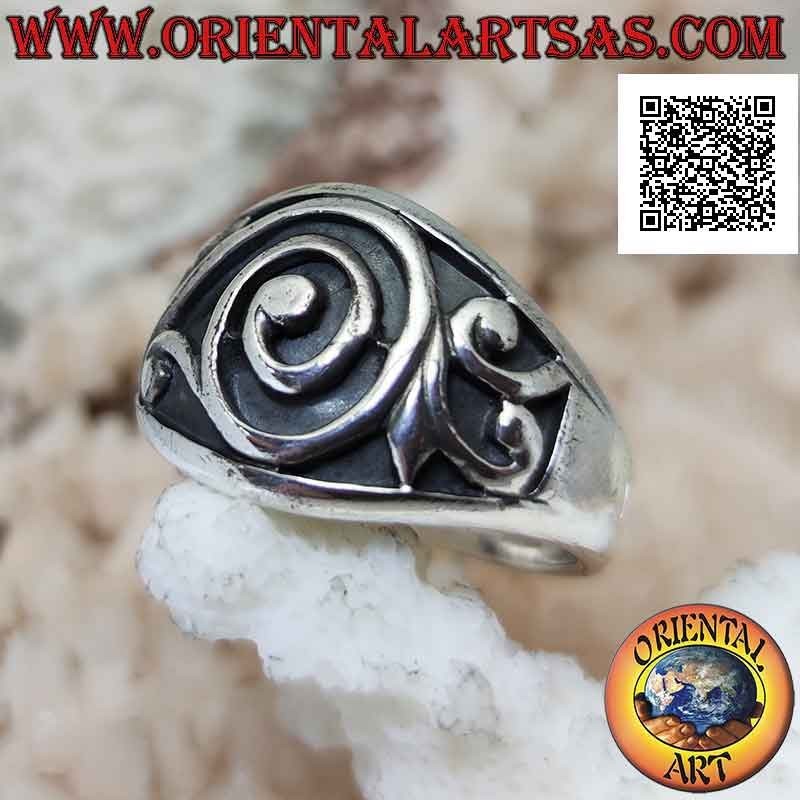Ring in silver with a wide growing band with a baroque spiral in bas-relief