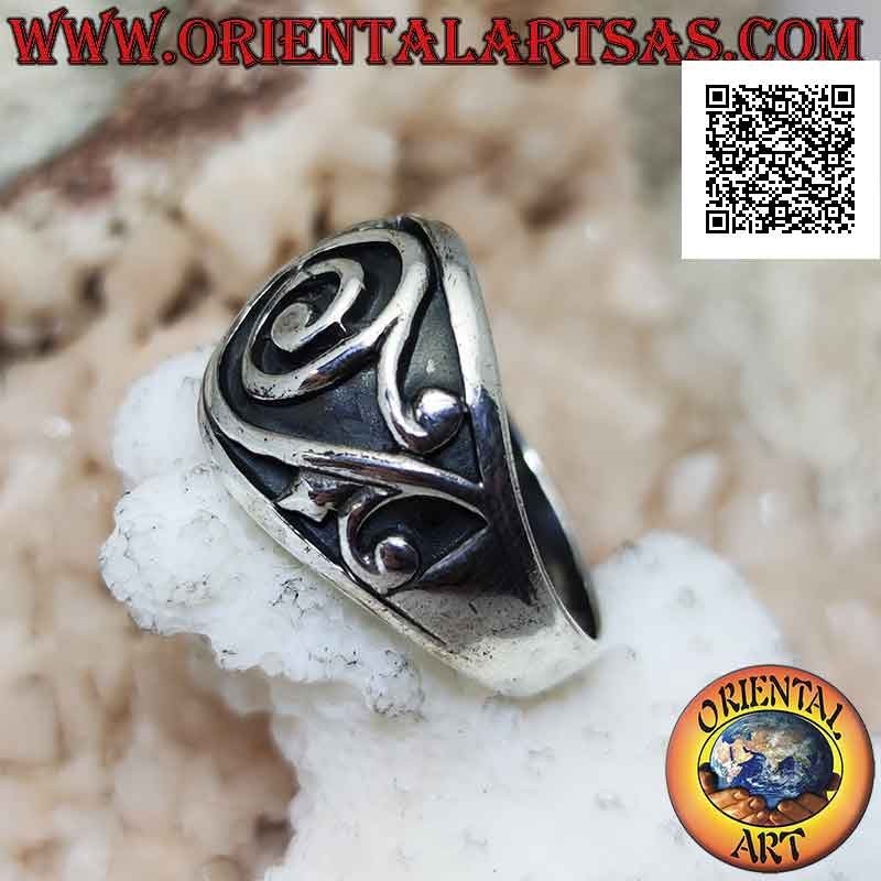 Ring in silver with a wide growing band with a baroque spiral in bas-relief