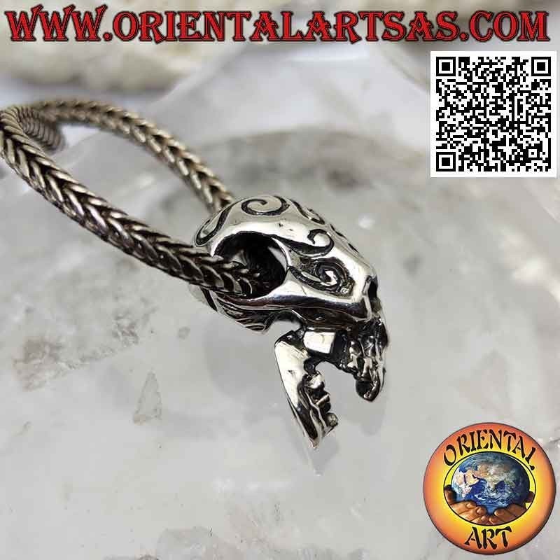 Silver pendant in the shape of a skull with engraved Maori and pierced temples