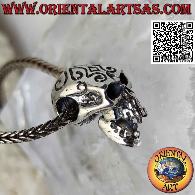 Silver pendant in the shape of a skull with engraved Maori and pierced temples