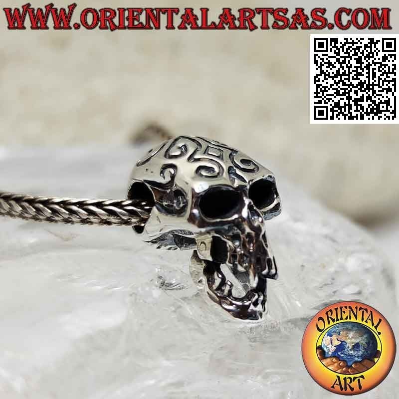 Silver pendant in the shape of a skull with engraved Maori and pierced temples