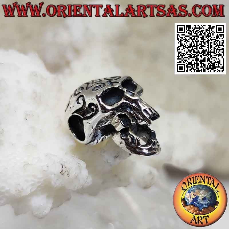 Silver pendant in the shape of a skull with engraved Maori and pierced temples