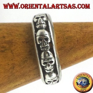 Anello a fascia in argento 925 con decorazione di teschi in fila ad altorilievo e finitura brunita.