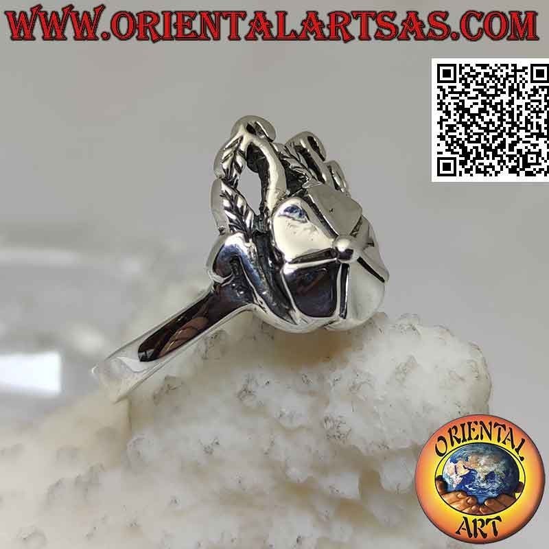 Anillo de plata, flor de loto suave sobre alfombra de hiedra