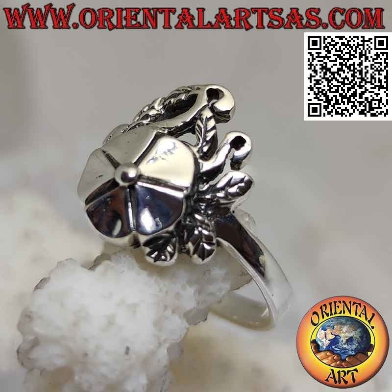 Anillo de plata, flor de loto suave sobre alfombra de hiedra