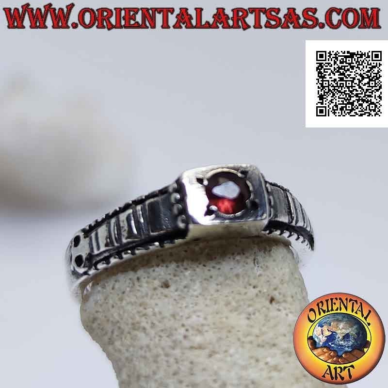 Silver ring with round garnet set in a raised square and checkered decoration