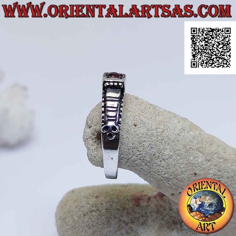 Silver ring with round garnet set in a raised square and checkered decoration