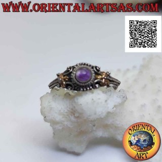 Ethnic style silver ring with round cabochon amethyst and 14 karat gold plates on the sides