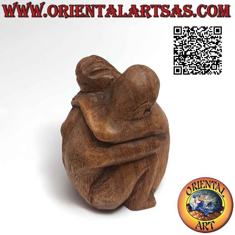 Escultura de pareja en abrazo consolador en madera de suar