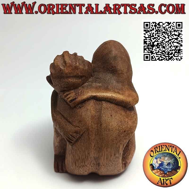 Scultura di una coppia in abbraccio consolatorio in legno di suar