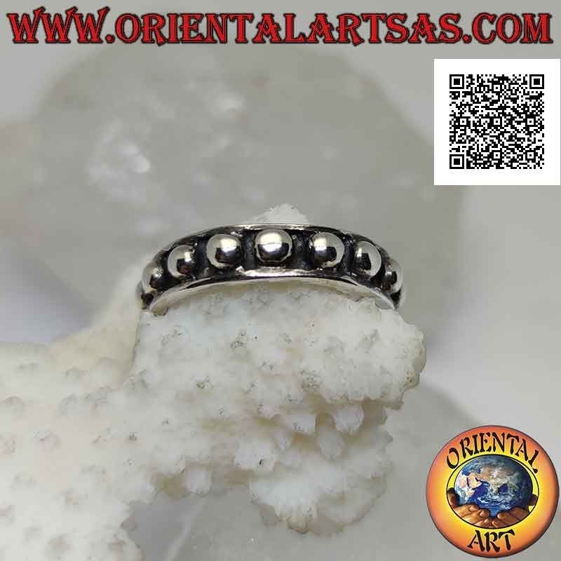 Anillo de plata con grandes esferas lisas sobre un fondo en bajorrelieve