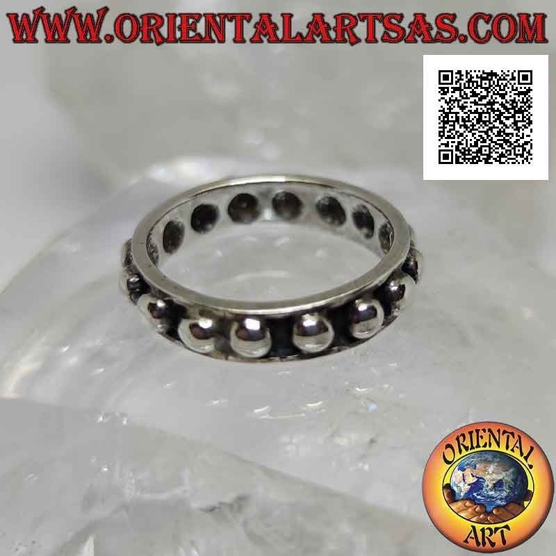 Anillo de plata con grandes esferas lisas sobre un fondo en bajorrelieve