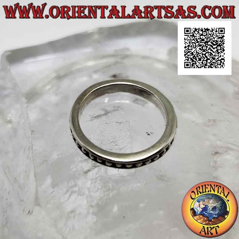 Silver band ring with small smooth spheres on a bas-relief background