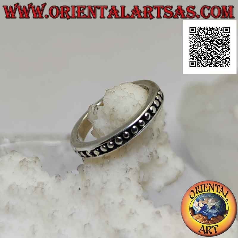 Anillo de plata con pequeñas esferas lisas sobre un fondo en bajorrelieve
