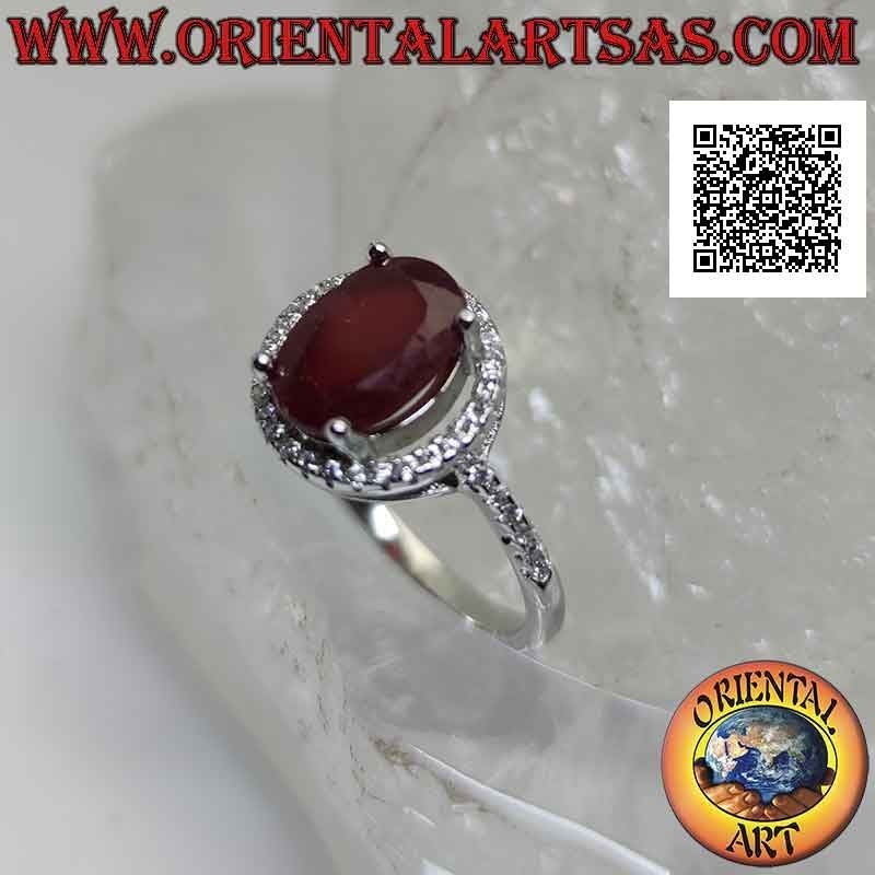 Silver ring with oval synthetic ruby set surrounded by zircons
