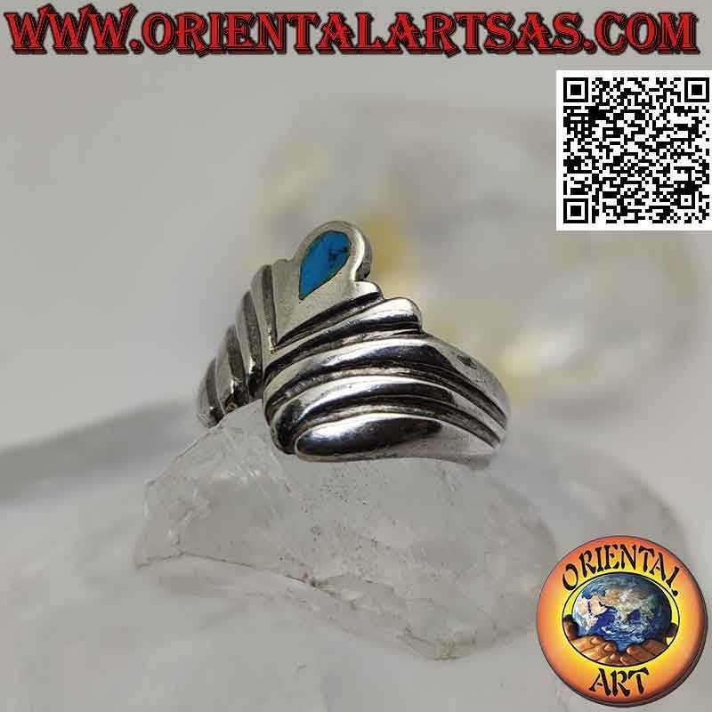 Anillo de plata con turquesa en forma de lágrima invertida entre una serie de líneas oblicuas en forma de V