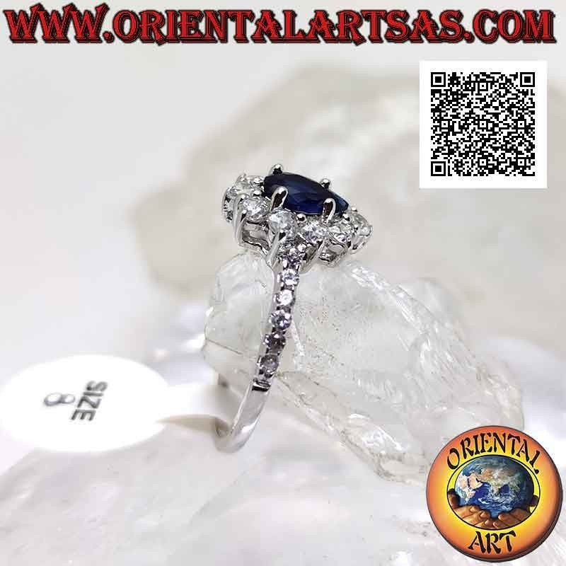 Silver ring with synthetic teardrop sapphire surrounded by round white zircons and on the sides