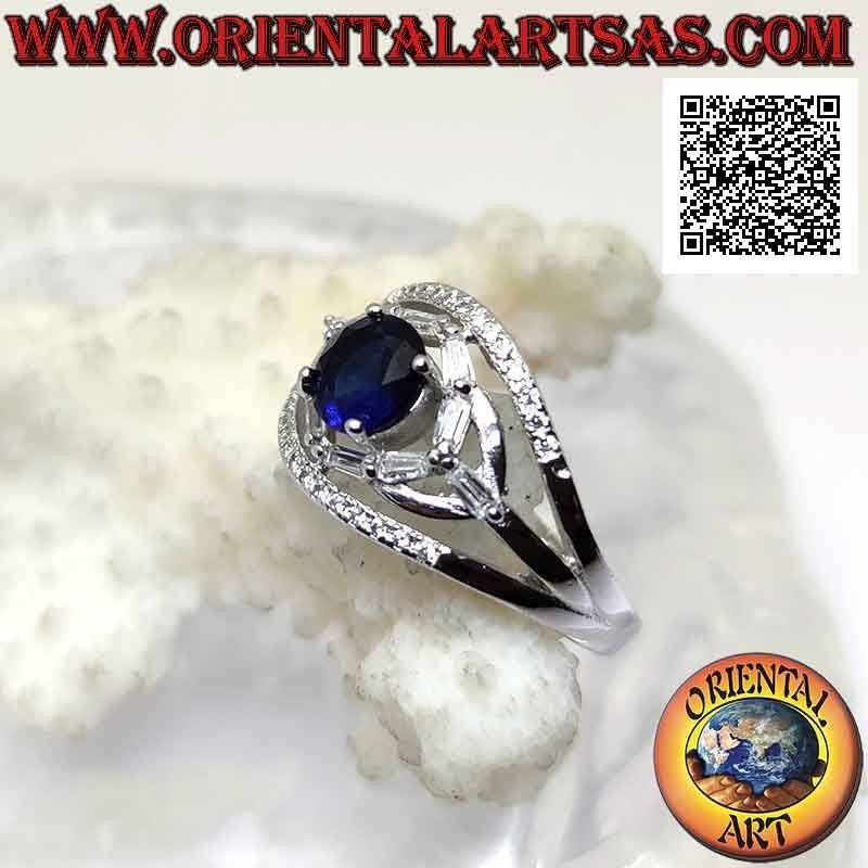 Silver ring with round synthetic sapphire set between elliptical games of white zircons