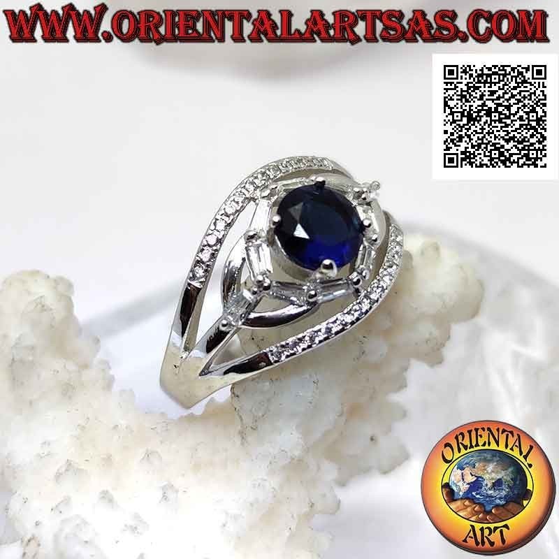 Anello in argento con zaffiro di sintesi tondo incastonato tra giochi ellittici di zirconi bianchi