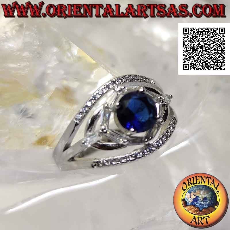 Bague en argent avec saphir synthétique rond serti entre jeux elliptiques de zircons blancs